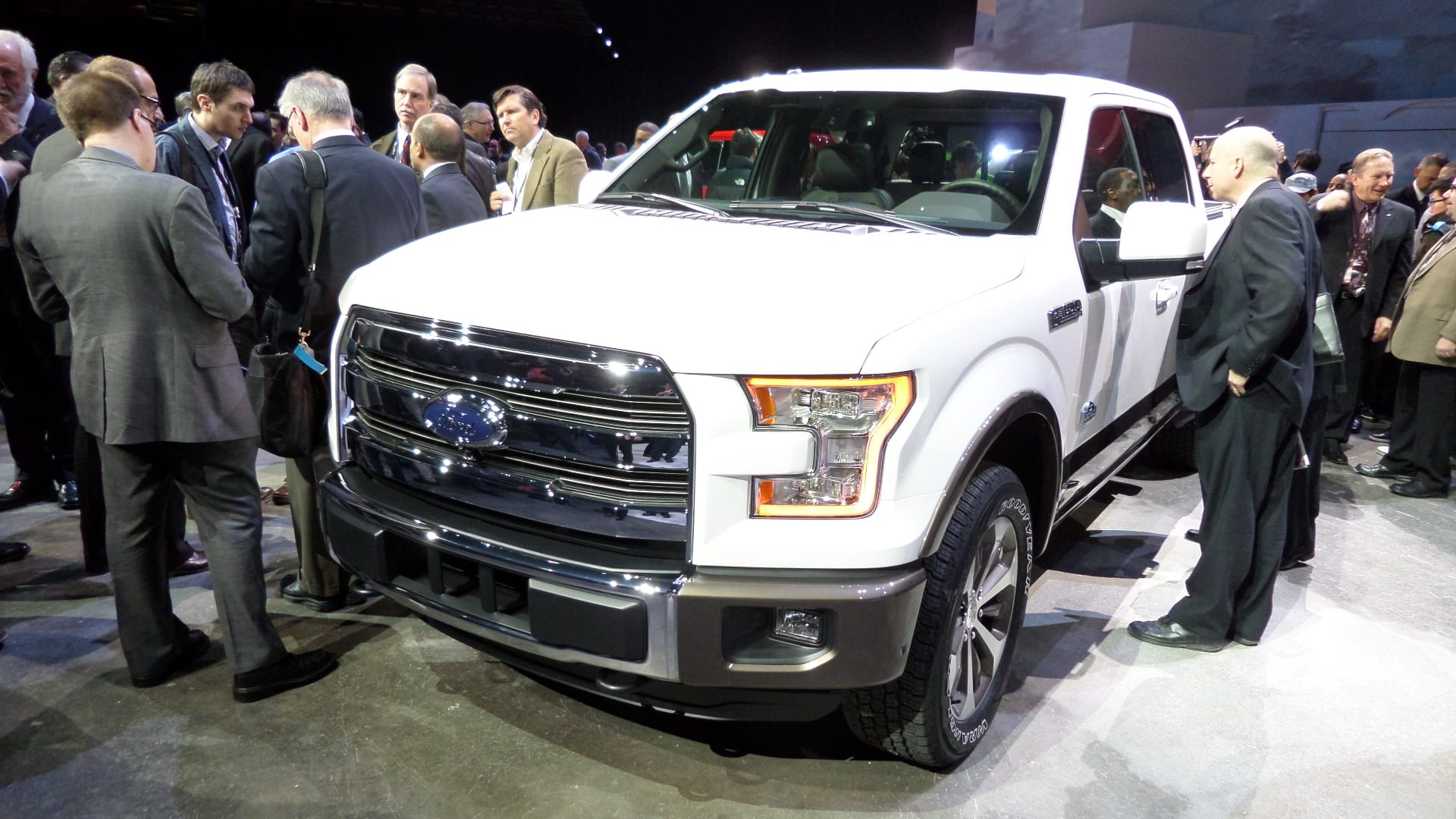A white 2015 Ford F-150 pickup truck. Front end.