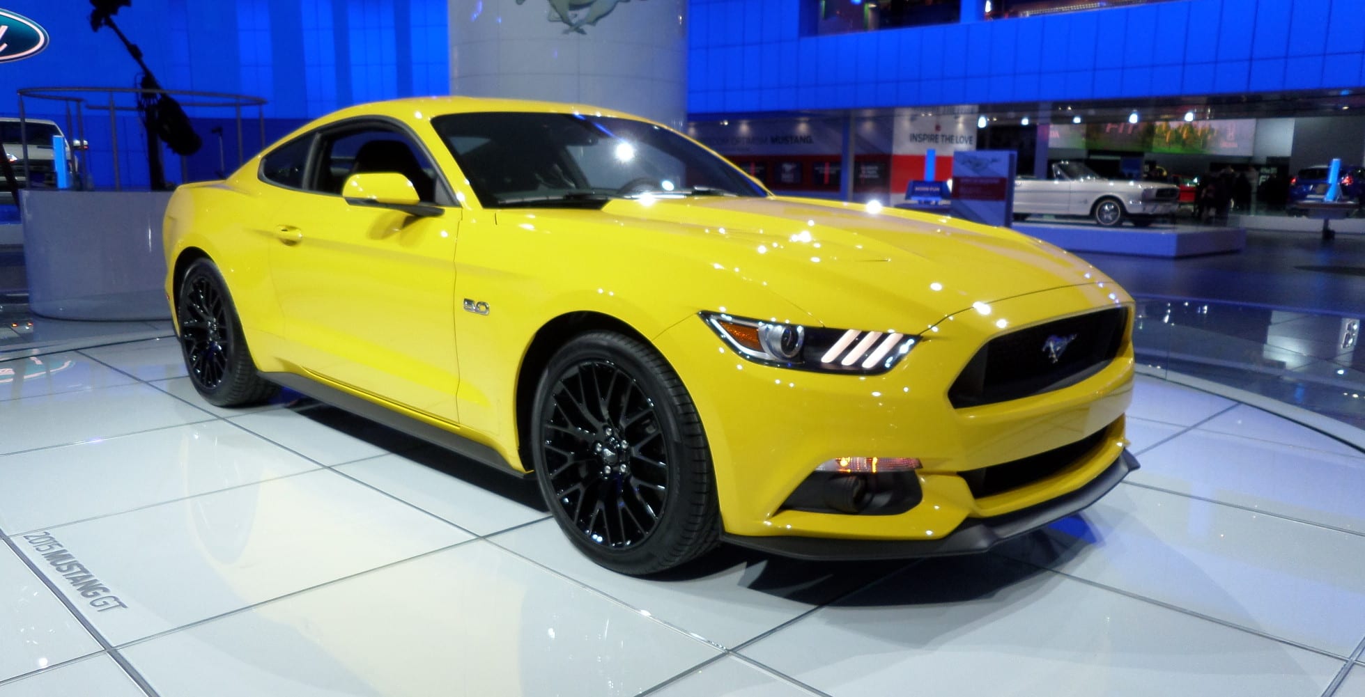 A yellow 2015 Ford Mustang sports car at the NAIAS.
