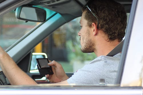 A man texting behind the wheel of a car